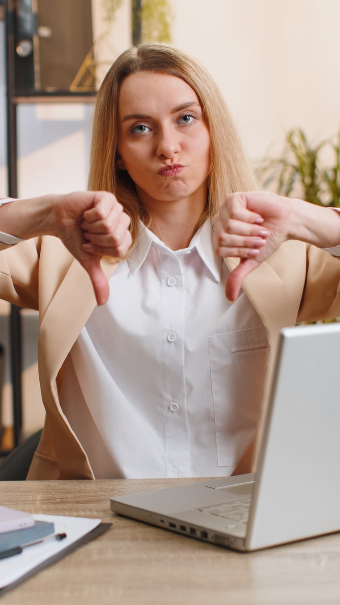 Upset businesswoman show thumbs down, dislike bad work, disapproval dissatisfied feedback at office